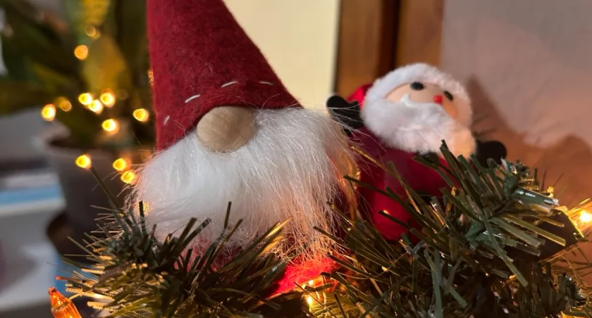 Zdjęcie pluszowego świętego mikołaja na czubku choinki 